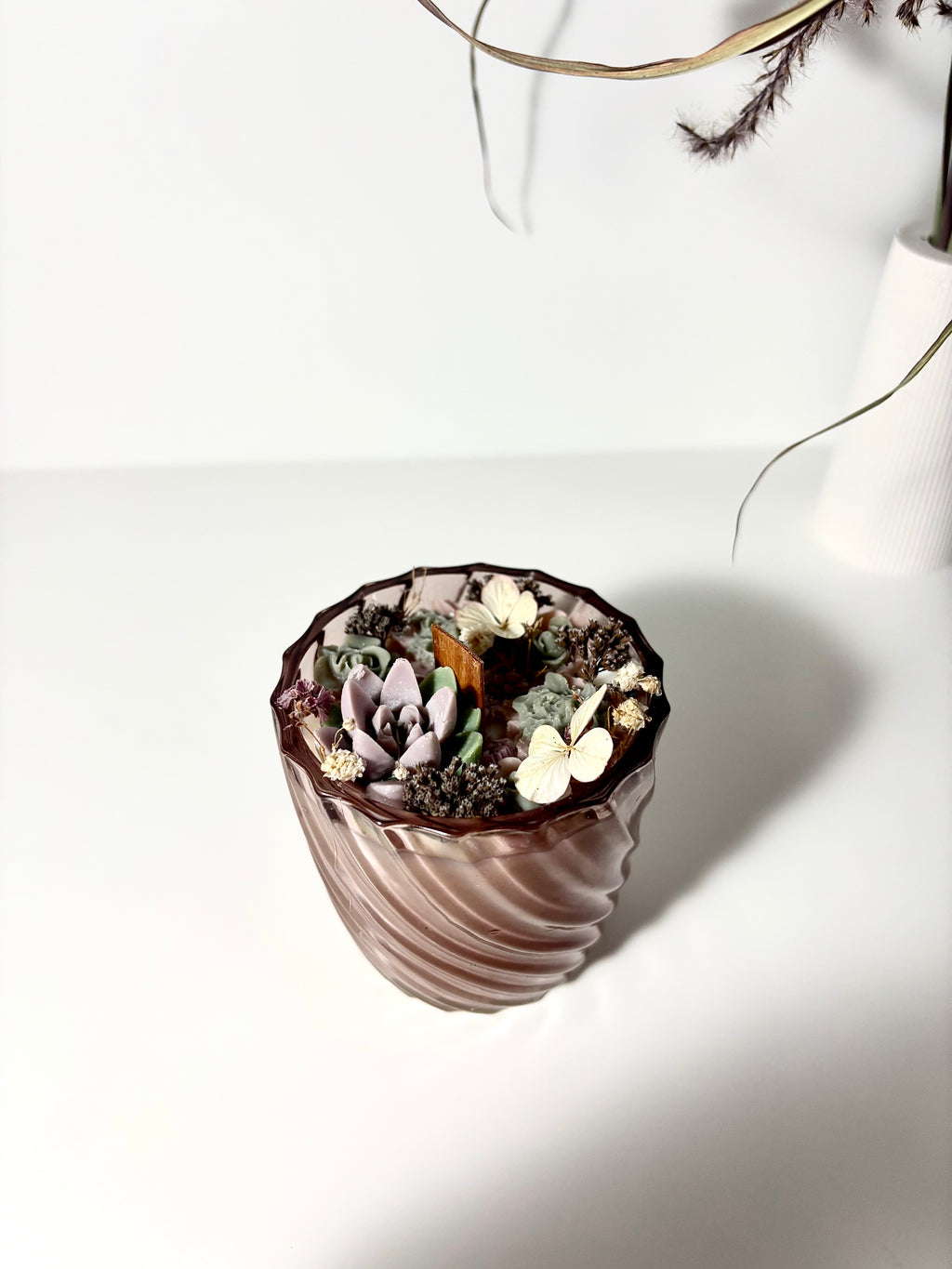 Žvakė stikliniame indelyje su gėlėmis