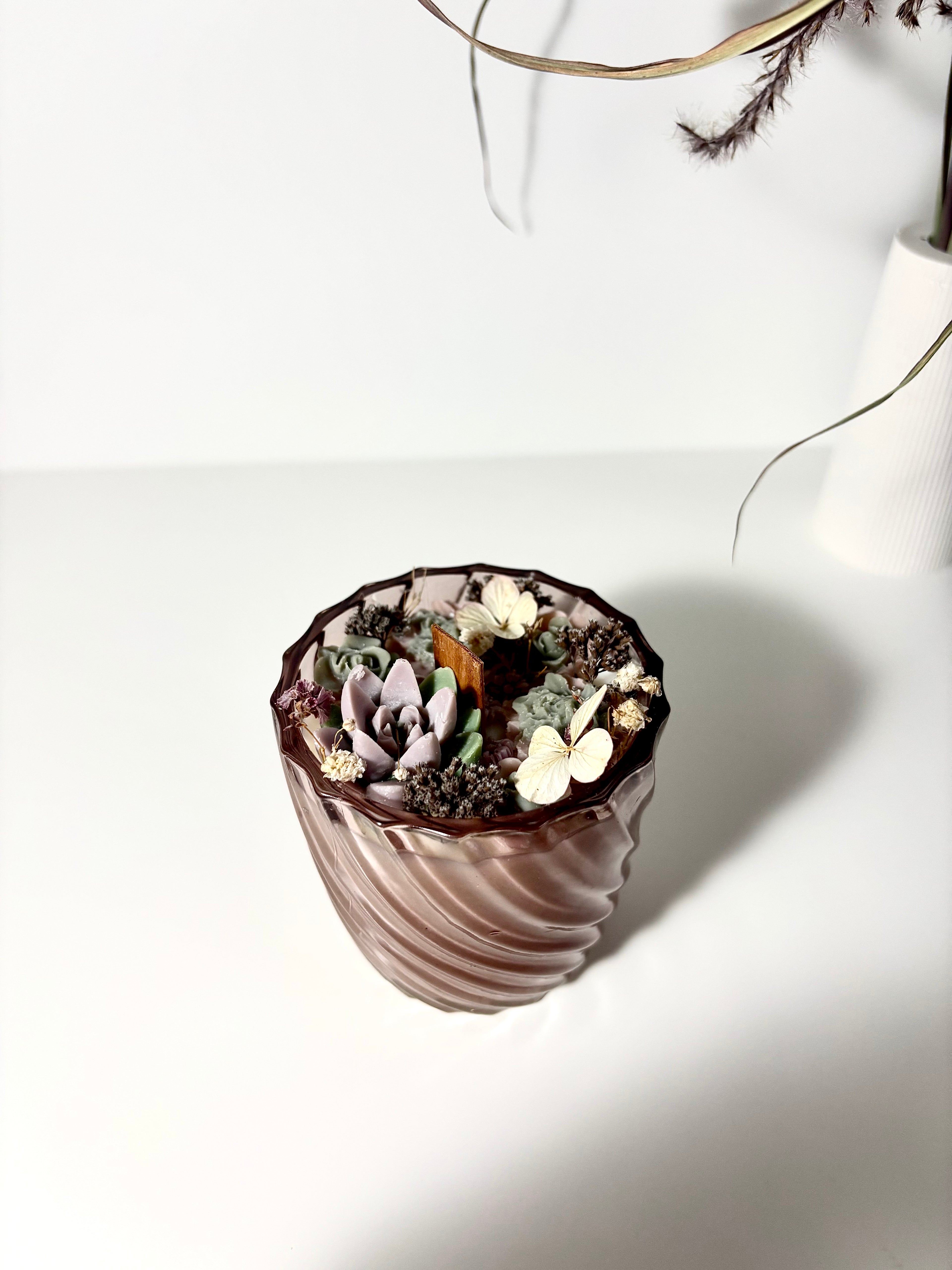 Žvakė stikliniame indelyje su gėlėmis