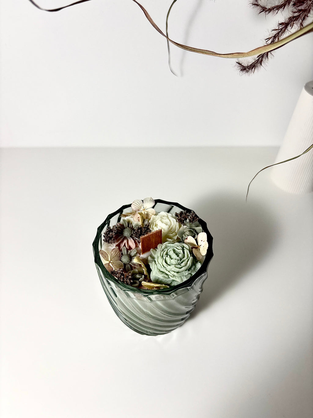 Žvakė stikliniame indelyje su gėlėmis