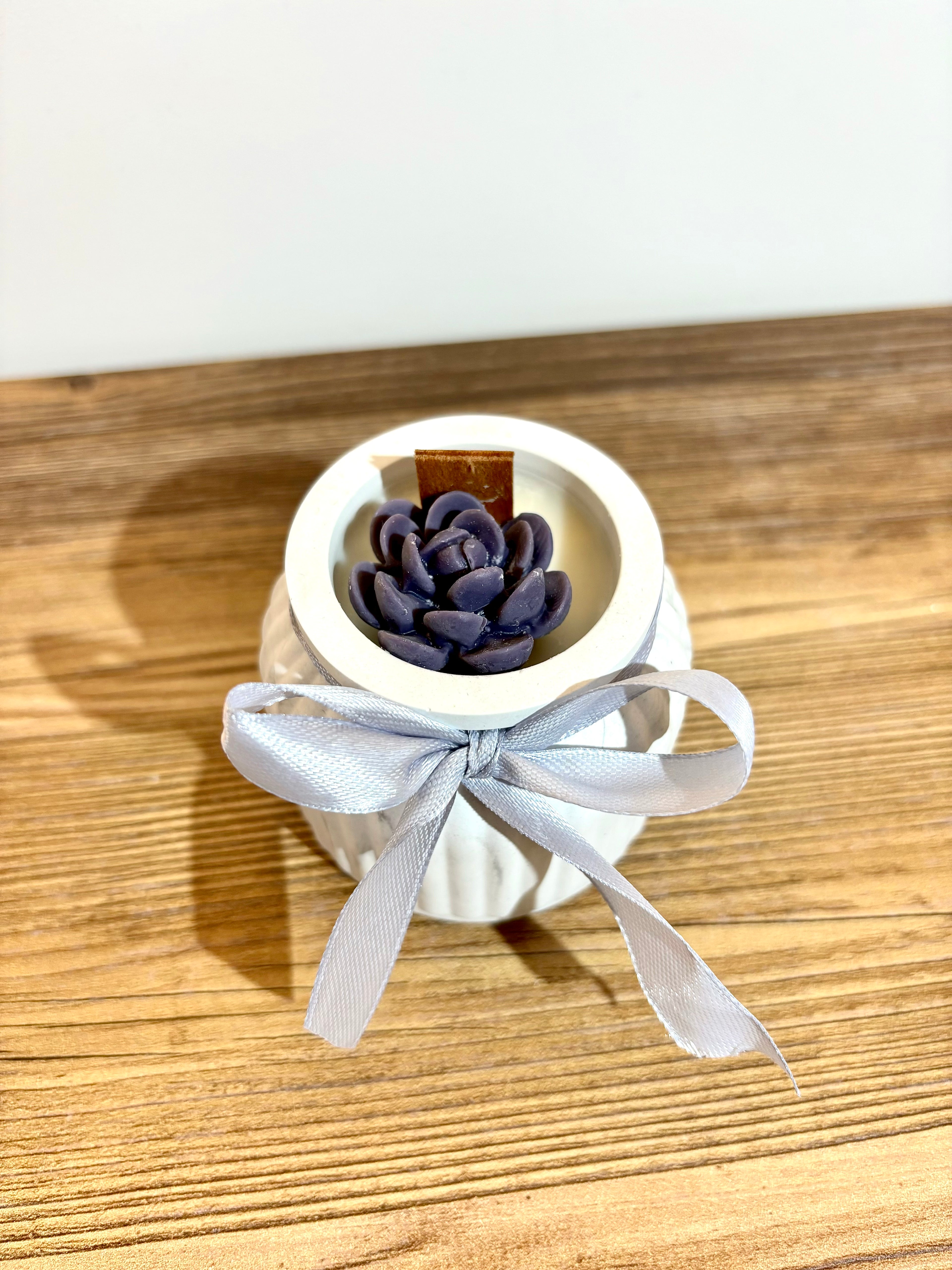 Vidutinė žvakė indelyje su kaspinėliu