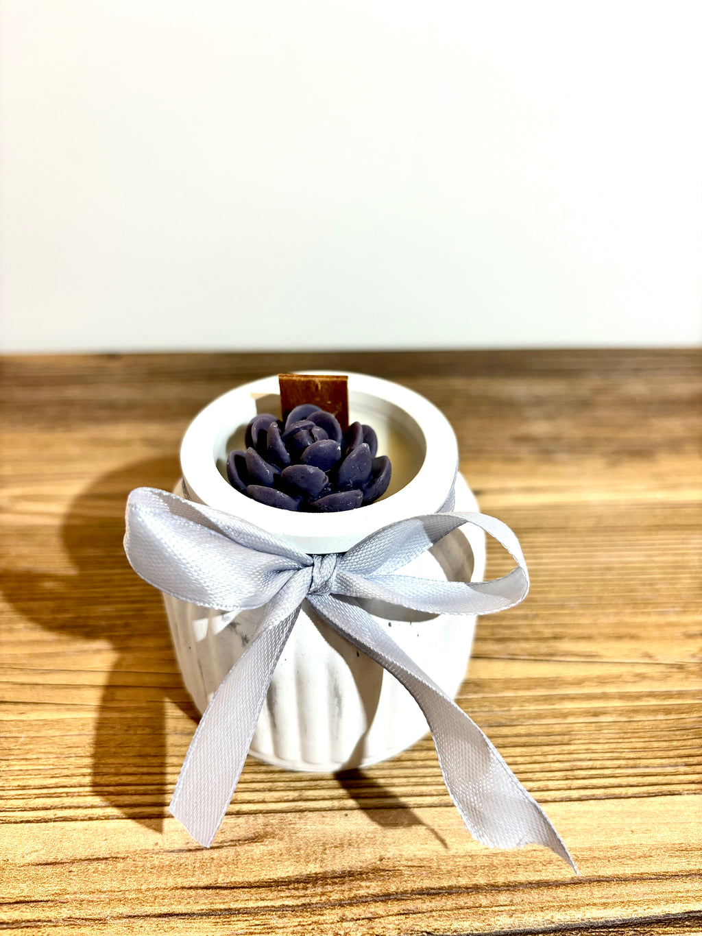 Vidutinė žvakė indelyje su kaspinėliu