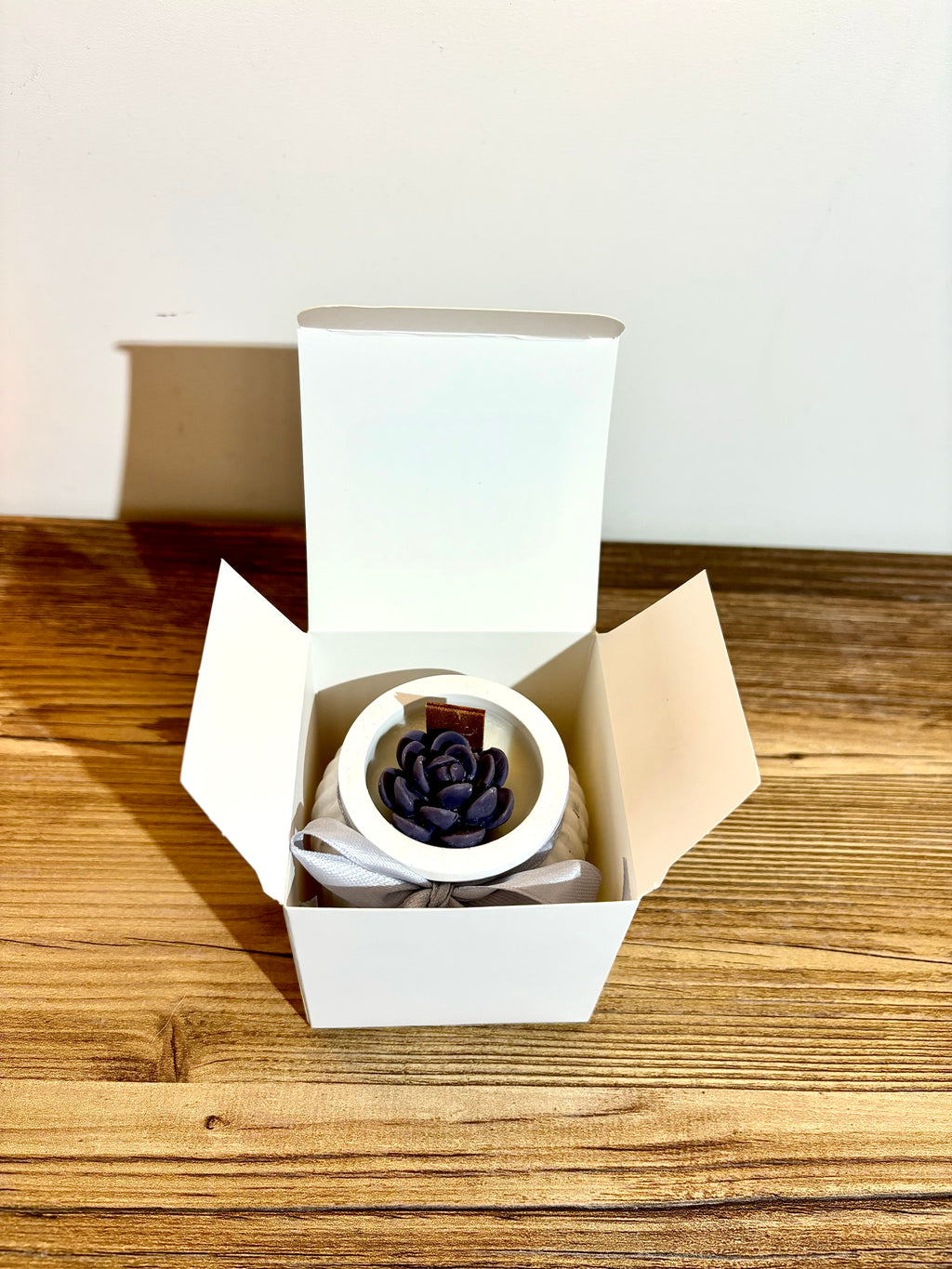 Vidutinė žvakė indelyje su kaspinėliu